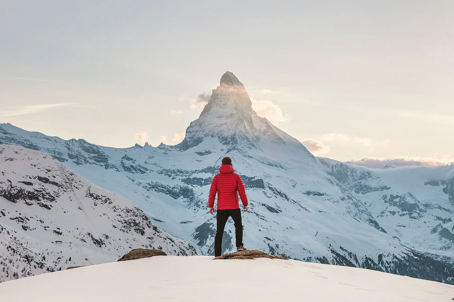 Hiker facing snow-covered mountains